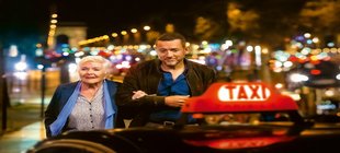 Alte Dame und junger Mann im nächtlichen Paris gehen zu einem Taxi