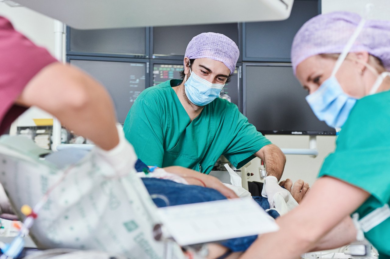 Zwei Pflegekräfte in versorgen einen Patienten nach einem kardiologischen Eingriff