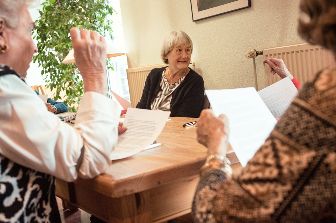 Seniorinnen sitzen an einem Tisch und unterhalten sich