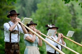 Alphornbläser in Tracht mit Alphörnern drei Menschen mit Instrument