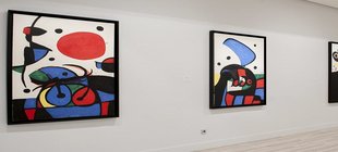 Vier farbenfrohe Bilder des Surrealismus von Joan Miro an einer Wand