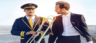 Der Dirigent läuft mit seinem Bruder barfuß am Strand