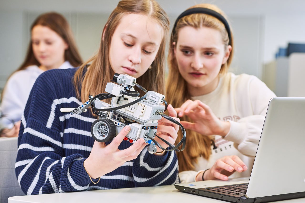 Zwei Schülerinnen überprüfen ihren Roboter im Fach Robotik