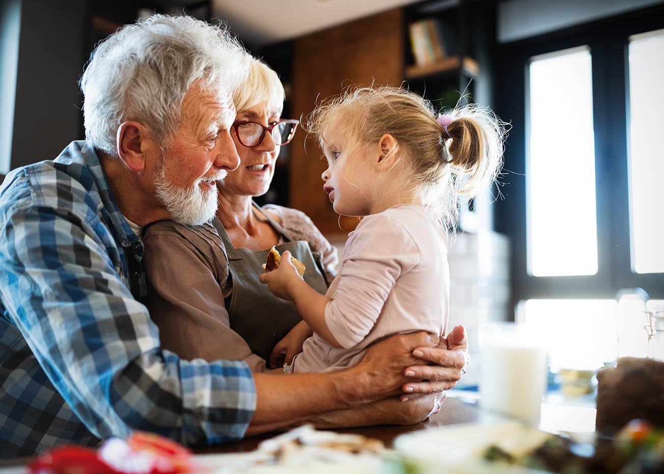 Großeletern halten fröhlich ihre Enkeltochter