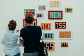 2 Frauen stehen vor moderner Wortkunst