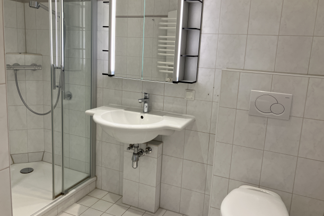 Eine Dusche, ein Waschbecken und eine Toilette im Badezimmer einer Wohnung der Seniorenresidenz Mölln 