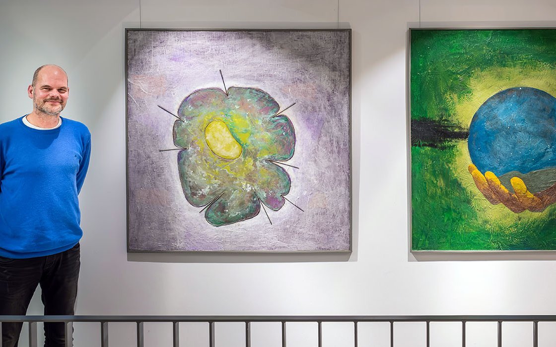 der Künstler Henning Diers vor zwei seiner Bilder im Augustinum Meersburg