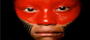 Nahe Portraitaufnahme einer amazonischen Einwohnerin mit auffälliger roter und schwarzer Gesichtsbemalung.