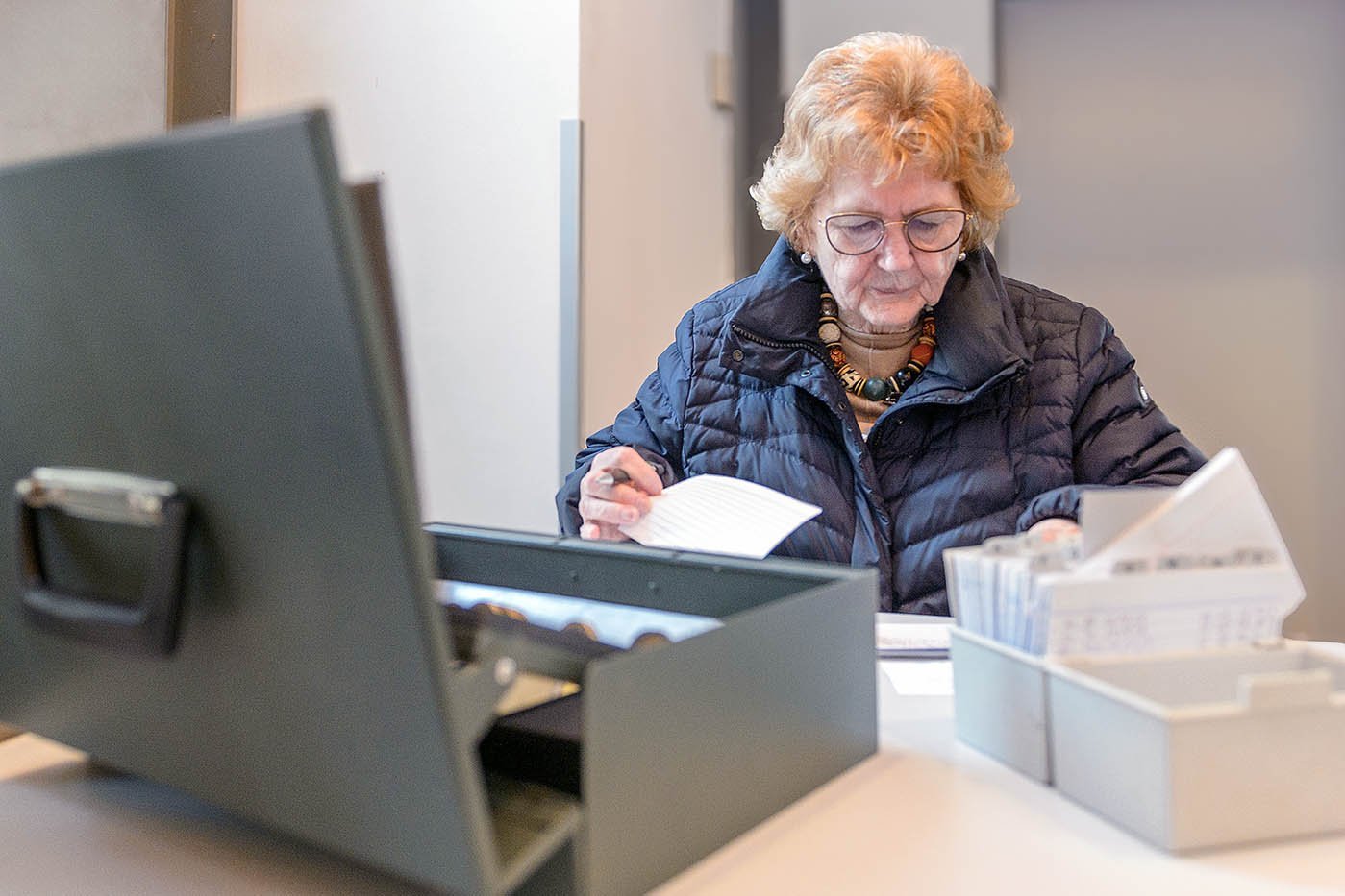  Barbara Wrage sitzt am Schreibtisch und checkt Unterlagen