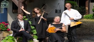 Vier Musiker und Musikerinnen mit Instrumenten