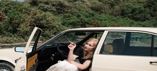 Frau sitzt rauchend im Auto