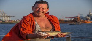 Mann präsentiert einen gefangenen Fisch
