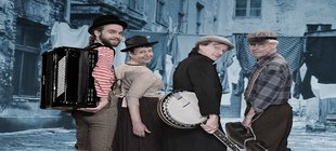 Vier Musiker mit Benjo, Akkordeon und Geige blicken über die Schulter