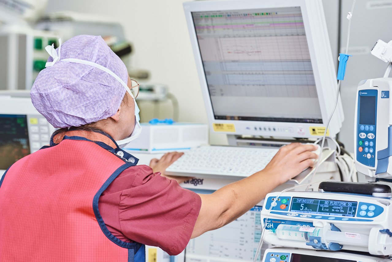 Eine OP-Pflegerin kontrolliert während eines Eingriffs am Monitor die Werte eines Pateinten