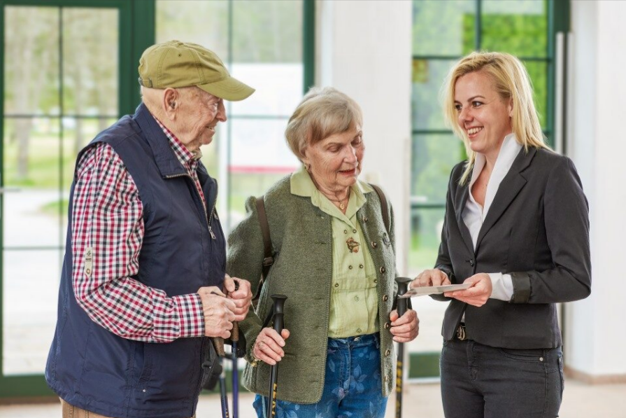 Ein Seniorenpaar unterhält sich mit einer Mitarbeiterin des Augustinum Berchtesgadener Land 