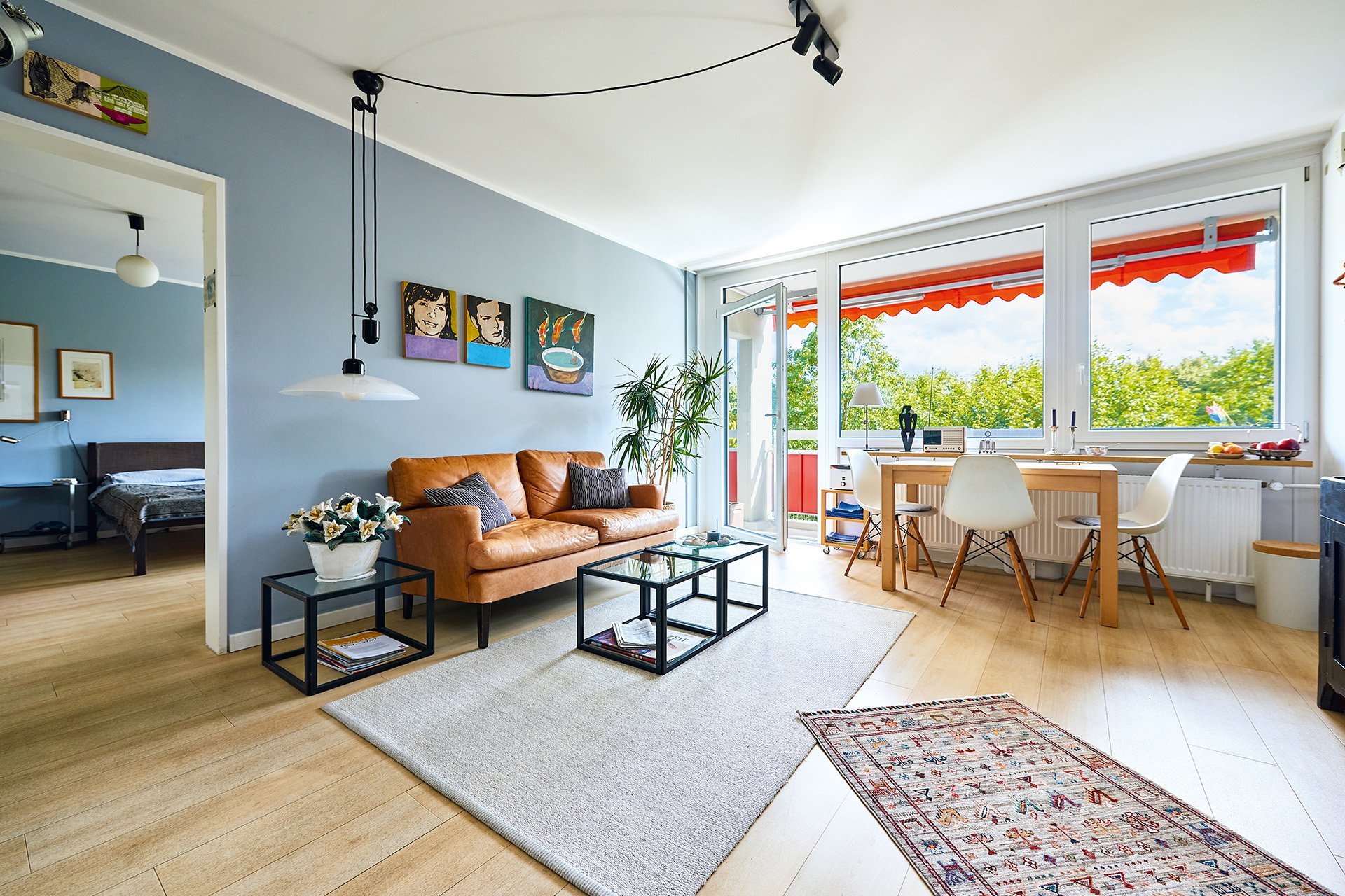 Eine Couch und ein Esstisch in einem großflächigen Wohnbereich eines Appartements