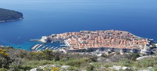 Die Stadt Dubrovnik von oben gesehen, rote Hausdächer, blaues Meer und grüne Landschaft