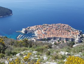 Die Stadt Dubrovnik von oben gesehen, rote Hausdächer, blaues Meer und grüne Landschaft