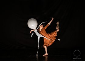 Eine Frau tanzt mit einem weißen Figur 