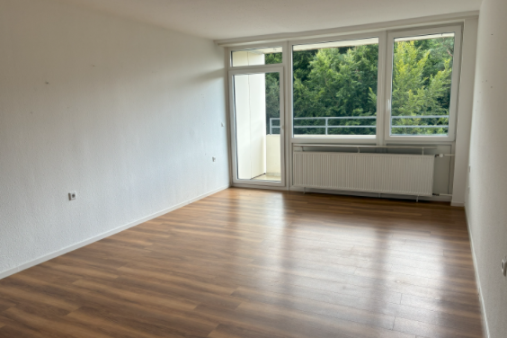 Ein Wohnzimmer ohne Möbel mit großen Fenstern