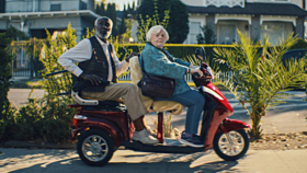 Ältere Frau und älterer Mann auf Motorroller