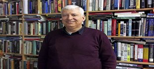 Prof. Hochgeschwender vor dem Bücherregal stehend
