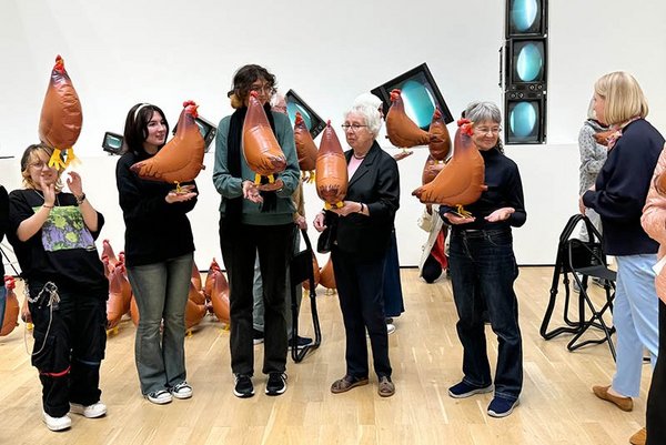 Mitglieder der Kunst-Kooperation posieren mit Ausstellungsstücken