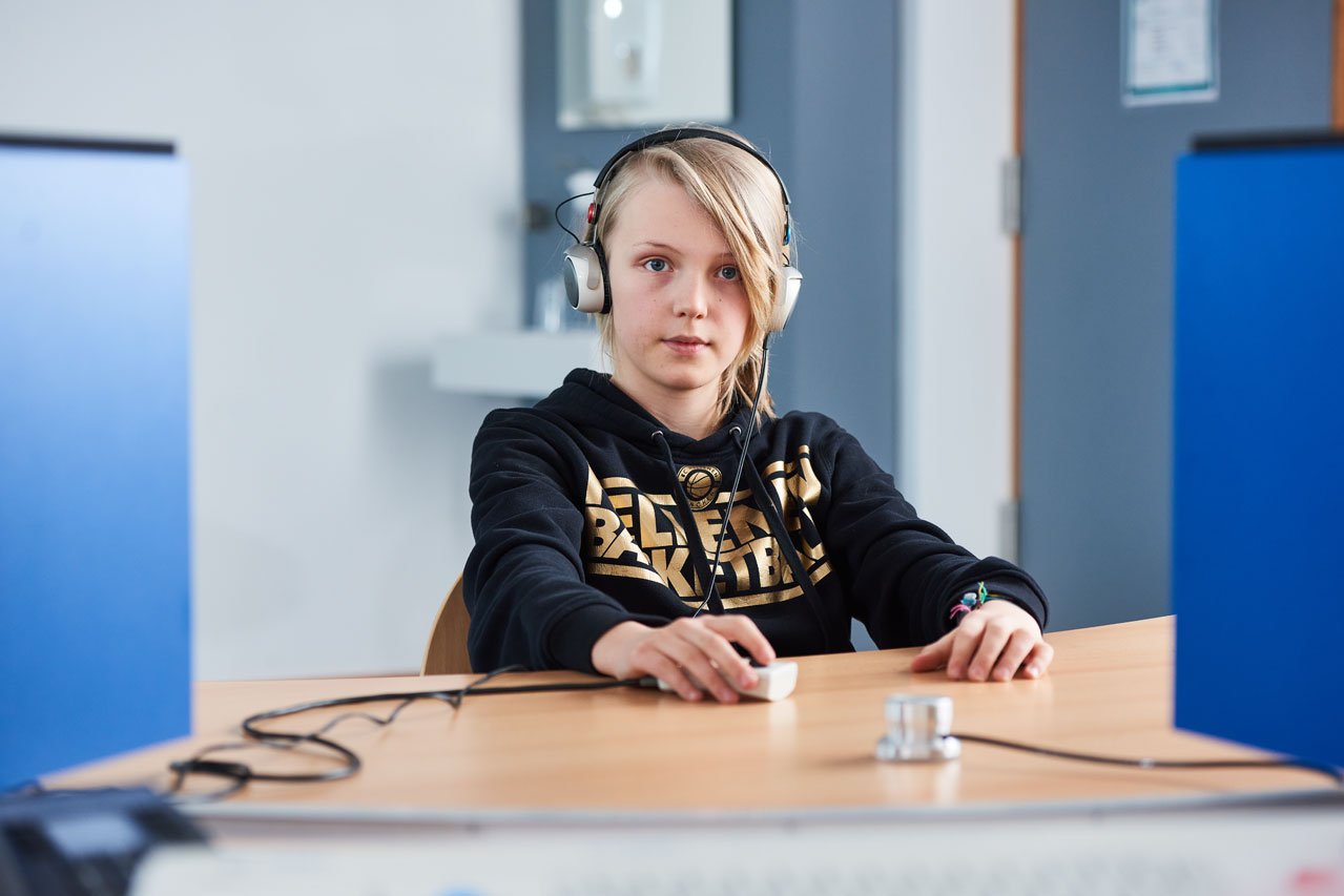 Ein Schüler mit Kopfhörern beim audiologischen Test