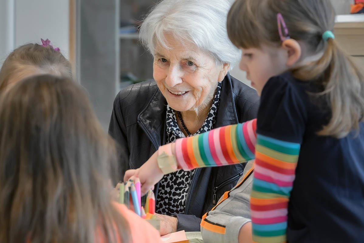 Lissy Benkler umringt von Kindergartenkindern an einem Tisch