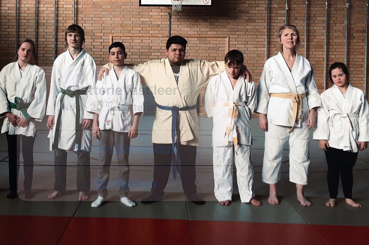 Behinderte Judoka stehen Arm in Arm nebeneinander