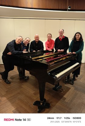 Fünf Personen stehen um einen Flügel