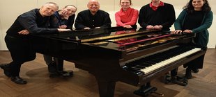 Fünf Personen stehen um einen Flügel