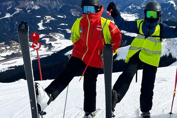 zwei Kinder mit Ski auf der Schneepiste