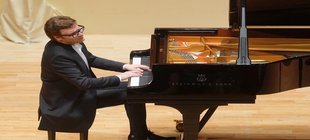Pianist Szwaikowski am Flügel sitzend