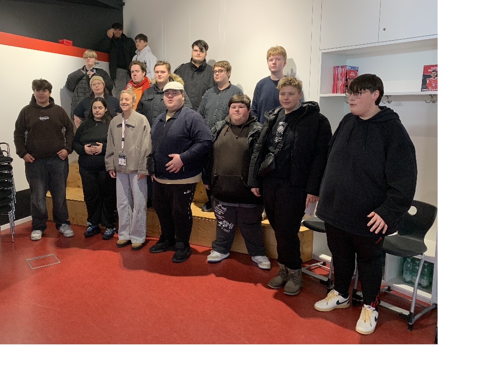 Gruppe von Jugendlichen in einem Raum mit Caro Simon, Spielerin beim FC Bayern Frauenfußball