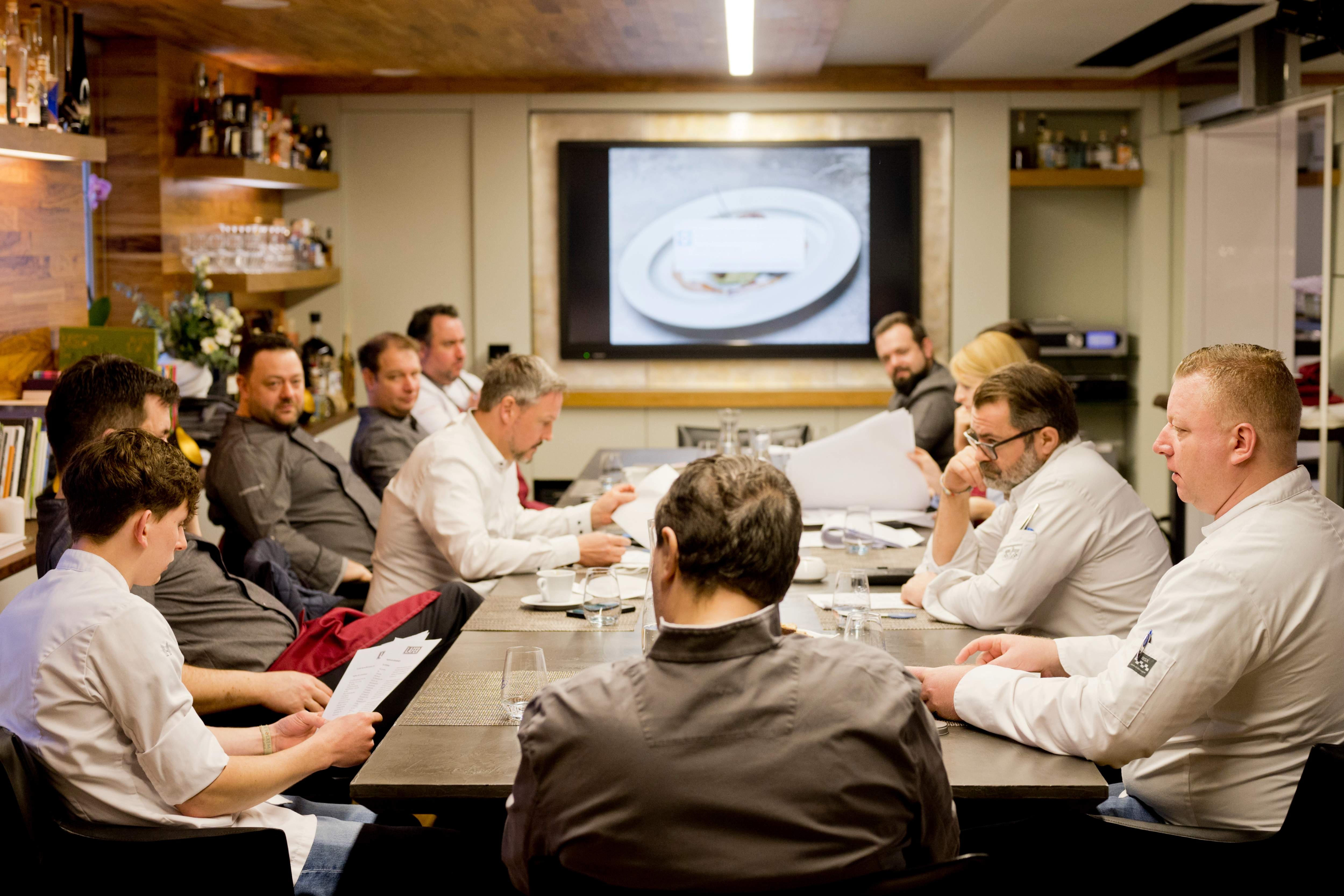 Das Team der Augustinum Gastronomie diskutiert an einem großen Tisch über die Augustinum Vital Gerichte