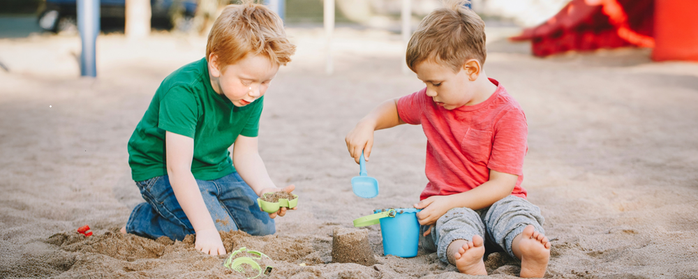 Zwei Kinder spielen im Sandkasten